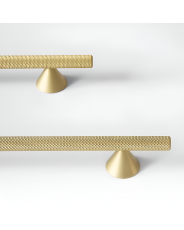 Tirador de mueble anodizado en oro/oro mate ONDIN tirador de diseño colocado sobre una superficie blanca