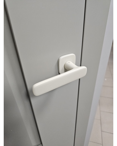Manija de puerta marfil mate FLOW diseño vista inclinada montada en una puerta