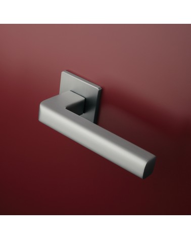 Tirador de puerta cromo satinado SALICE ferretería diseño montada en una puerta