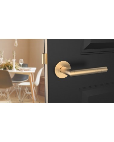 Manija de puerta color oro mate ARABIS diseño vista de frente montada en una puerta