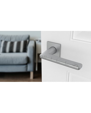Tirador de puerta cromo satinado SETIA tirador de diseño vista desde arriba inclinada montada en una puerta