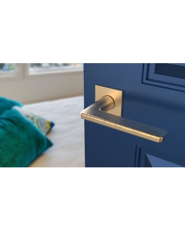 Tirador de puerta oro mate SETIA manilla design vista superior inclinada montada en una puerta