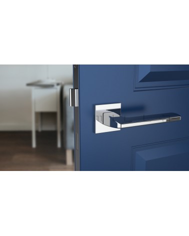 Tirador de puerta cromo pulido YUKA herrajes de diseño vista frontal montada en una puerta