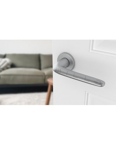 Tirador de puerta cromado satinado AZALIA tirador de diseño vista inclinada montado en una puerta