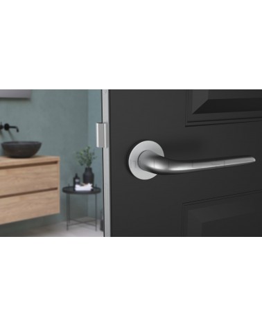 Tirador de puerta cromado satinado AZALIA tirador de diseño vista de frente montado en una puerta