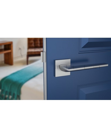 Tirador de puerta cromo satinado LUNARIA tirador de diseño vista frontal montado en una puerta