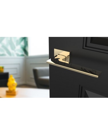 Manilla de puerta oro pulido LUNARIA manilla de diseño vista superior inclinada montada en una puerta
