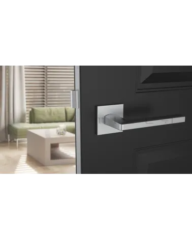 Tirador de puerta cromo satinado PYROLA herrajes de diseño vista frontal montada en una puerta