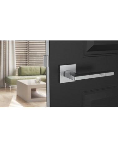 Tirador de puerta cromo satinado PYROLA herrajes de diseño vista frontal montada en una puerta