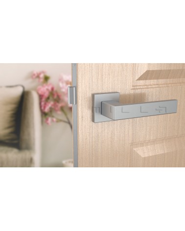 Manija de puerta cromo satinado PINA manija de diseño vista frontal montada en una puerta