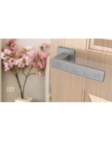 Tirador de puerta PINA en cromo satinado diseño vista inclinada montada en una puerta