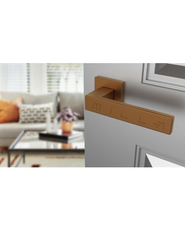 Tirador de puerta PINA en cobre diseño vista inclinada montada en una puerta