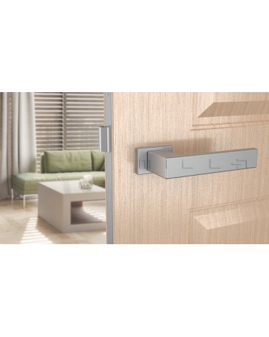 Tirador de puerta PINA cromada satinada de diseño vista frontal montada en una puerta