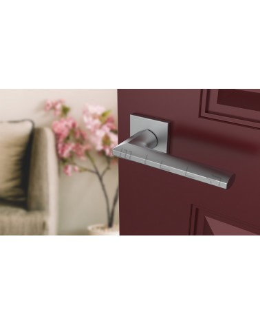 Tirador de puerta cromo satinado JASMINA tirador de diseño vista inclinada montada en una puerta