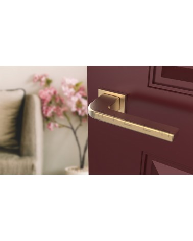 Manija de puerta oro mate ISMENA ferretería diseño vista inclinada montada en una puerta