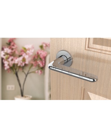 Tirador de puerta cromo pulido LIRA tirador de diseño vista superior inclinada montado en una puerta