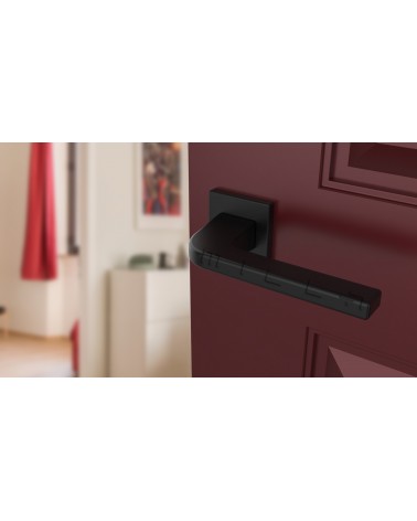 Tirador de puerta negro ISMENA tirador de diseño montado en una puerta entreabierta