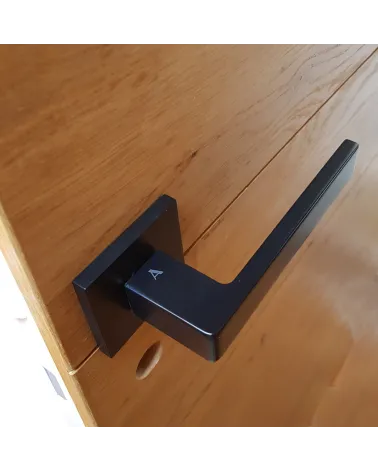Tirador de puerta de zamak SULLA manilla de diseño montada en una puerta motivo madera