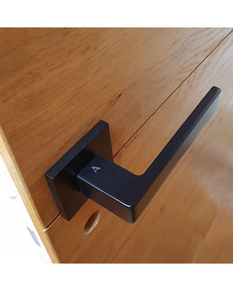 Tirador de puerta de zamak SULLA manilla de diseño montada en una puerta motivo madera