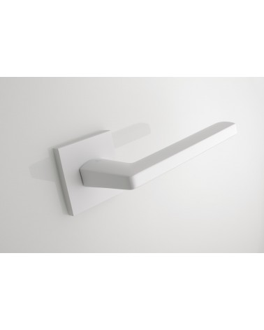 Palanca de puerta blanca PYROLA herraje de diseño vista desde arriba inclinada alejada montada en una puerta