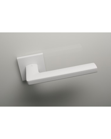 Palanca de puerta blanca PYROLA herraje de diseño vista desde arriba ligeramente inclinada montada en una puerta