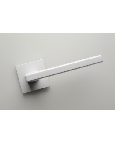 Palanca de puerta blanca PYROLA herraje de diseño vista frontal inclinada montada en una puerta