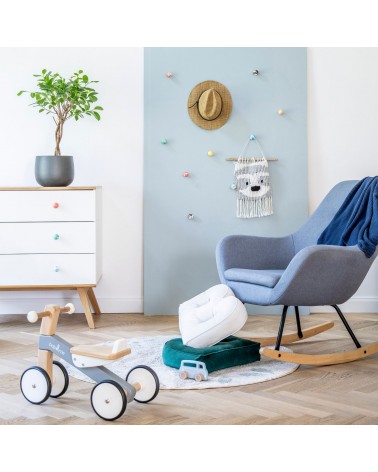 Botón de mueble de madera de haya rosa, tirador de diseño fijado en una cómoda blanca en un dormitorio