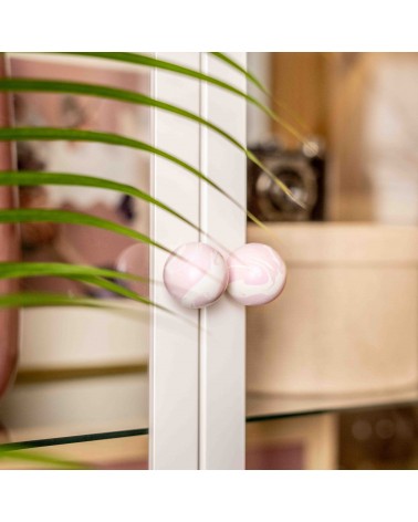Botón de mueble de madera de haya lila, tirador de diseño en vista inclinada fijado en una puerta acristalada con fondo desenfoc
