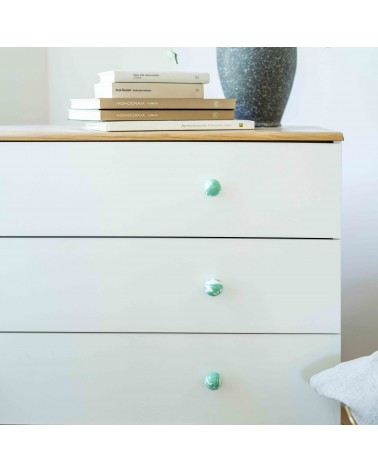 Botón de mueble de madera de haya verde intenso, tirador de diseño instalado en una cómoda blanca