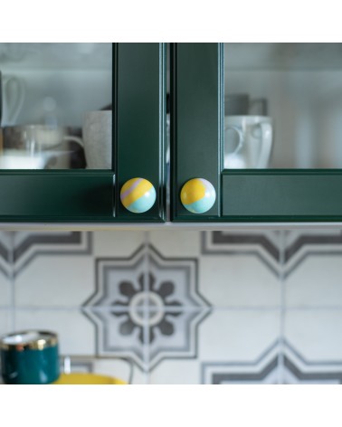 Botón de mueble de madera de haya amarillo funky, tirador de diseño visto de frente fijado en un mueble de cocina