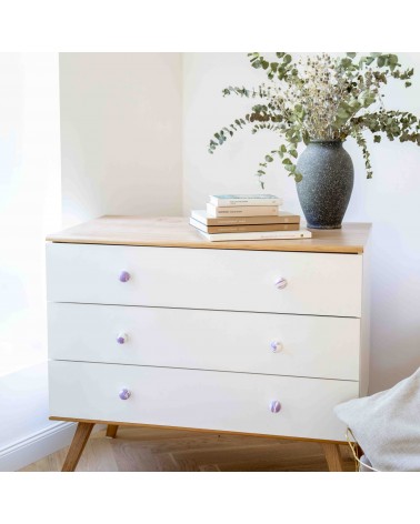 Botón de mueble en madera de haya berenjena tirador de diseño instalado en una cómoda blanca coronada por una planta en maceta
