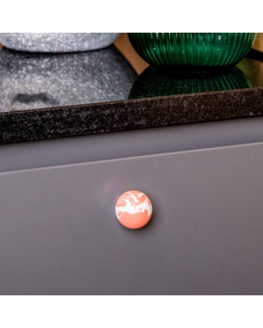 Botón de mueble en madera de haya rojo cereza tirador de diseño vista de cerca montado en un mueble de cocina
