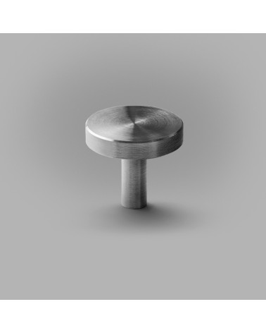 Botón de mueble cromo pulido NENA M tirador de diseño colocado sobre una superficie gris