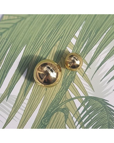 Botón de mueble dorado pulido ODETE tirador de diseño colocado sobre un fondo con motivo