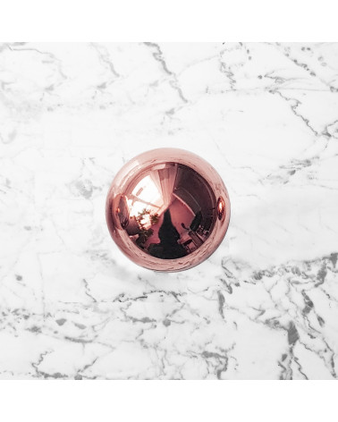 Botón de mueble cobre ODETE M tirador de diseño visto desde arriba sobre una superficie marmolada