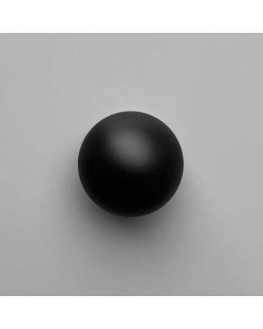 Botón de mueble en latón ODETE BLACK M tirador de diseño visto de frente sobre una superficie clara