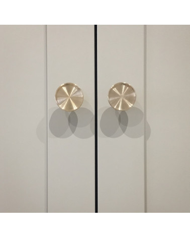 Botón de mueble en latón INA tirador de diseño vista de frente montado en un mueble