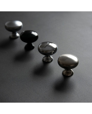 Botón de mueble TORONTO tirador de diseño dispuestos en diagonal sobre una superficie oscura
