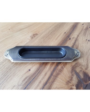 Tirador para puerta corredera sobrio MANDELLI 1028 herraje de diseño color 3 colocado sobre una placa de madera
