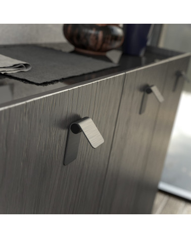 Tirador de mueble acero inoxidable/negro mate TORN-1 tirador de diseño visto de lado fijado en un mueble
