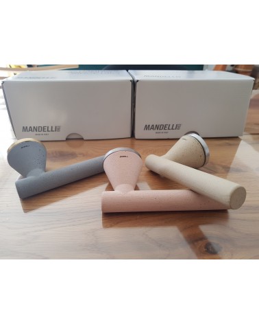 Tirador de puerta futurista Mandelli Juno tirador de diseño tres colores colocada sobre una mesa fondo packaging