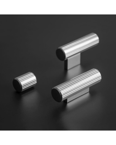 Tirador de mueble cromado brillante AVANTI en T diseño posado sobre una superficie oscura