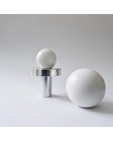 Botón de mueble en latón POLA WHITE tirador de diseño dispuesto sobre un fondo en primer plano