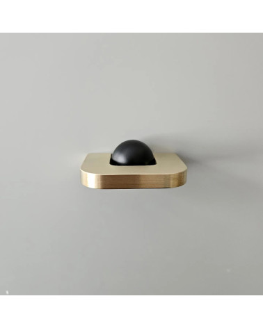 Tirador de mueble en oro pulido ISA XS tirador de diseño visto desde arriba con bola negra sobre fondo gris