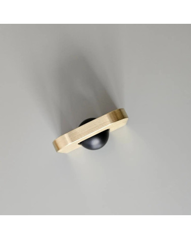 Tirador de mueble en oro pulido ISA XS tirador de diseño visto desde arriba inclinado con bola negra sobre fondo gris