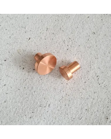 Botón de mueble en latón NENA tirador de diseño colocados uno al lado del otro sobre una superficie plana