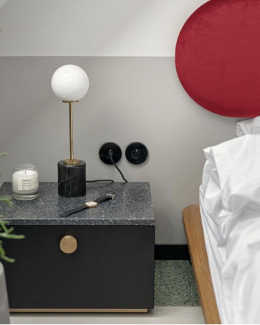 Tirador de mueble dorado mate TOVE tirador de diseño vista de frente instalado en una mesita de noche en un dormitorio
