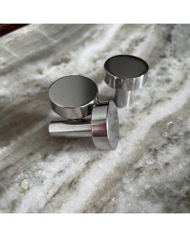 Tirador de mueble cromo pulido NENA diseño vista ampliada colocado sobre una superficie marmolada