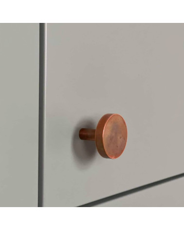 Tirador de mueble de latón NENA M diseño visto de lado montado en un mueble