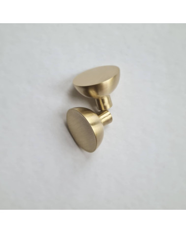 Tirador de mueble dorado mate LUNA M diseño colocados uno al lado del otro sobre una superficie plana